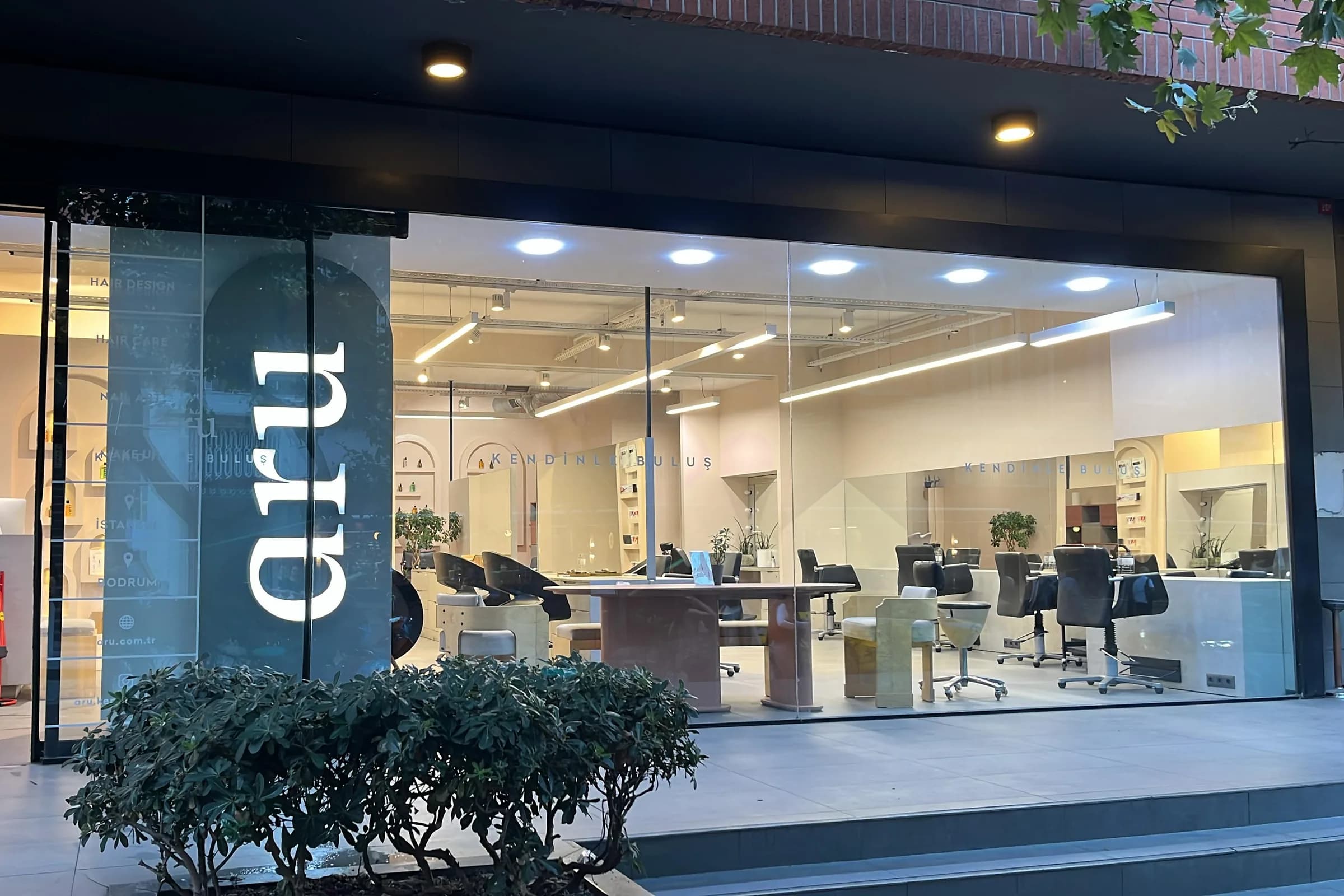aru İstanbul salonunun cam cephesi: vitrinde aru logosu, arkada kemerli ürün nişleri ve çalışma bölümü