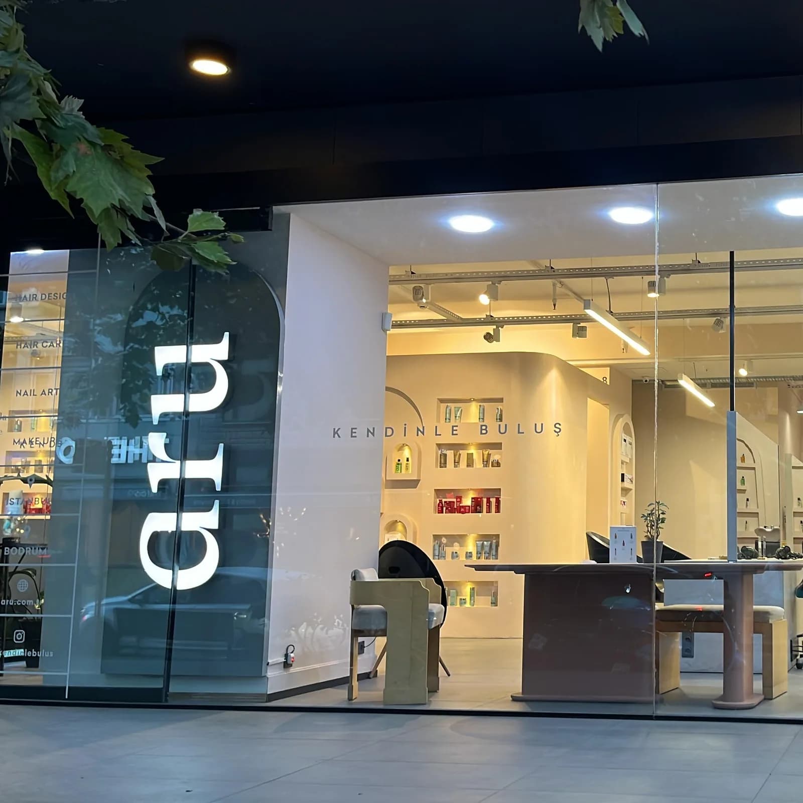 aru İstanbul salonunun vitrini: solda cam üzerinde aru logosu ve hizmet listesi, arkada ürün nişleri ve karşılama masası